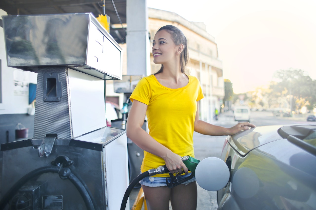 Girl smiles and refuels the car